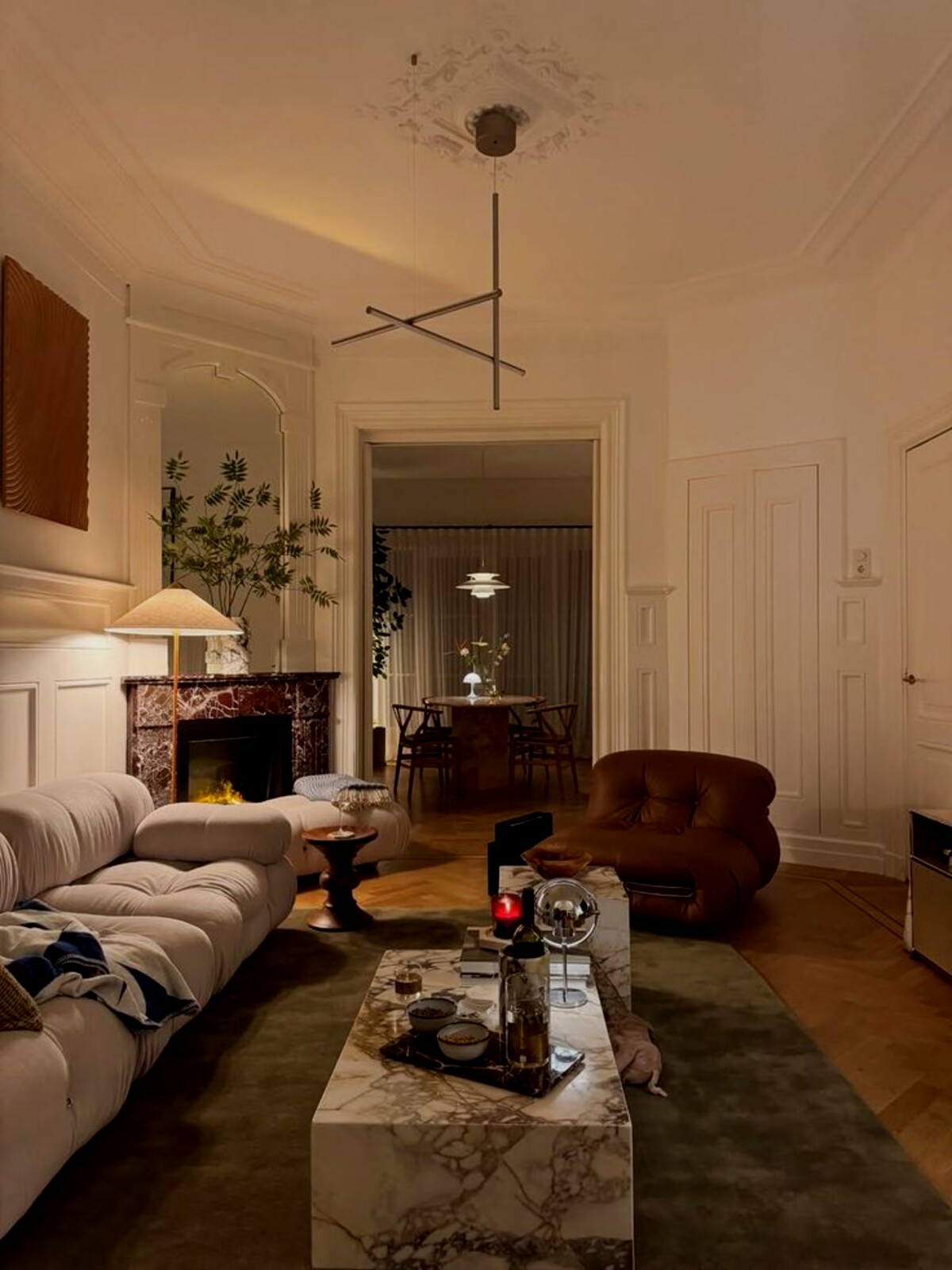 Chic living room with a marble fireplace, boucle sofa, and warm layered lighting
